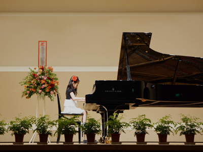 発表会でグランドピアノを演奏する少女